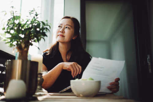 Asian senior woman working at home with a laptop
