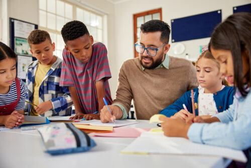 teacher in a classroom reading with students.