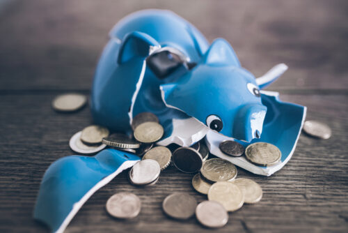 closeup of shattered broken piggy bank with coins
