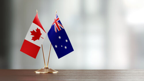 Australian and Canadian flag pair on desk.