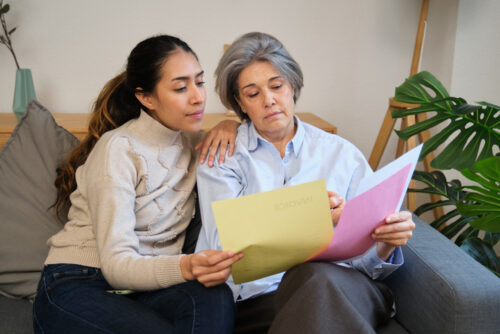 Latino Daughter supporting senior mother with paperwork and invoices