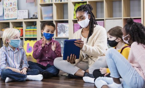 Preschool teacher, students in class, wearing masks