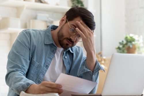 Upset frustrated young man holding reading postal mail letter