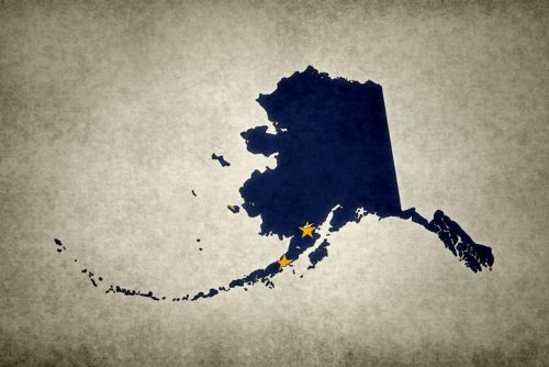 Grunge map of the state of Alaska with its flag printed within