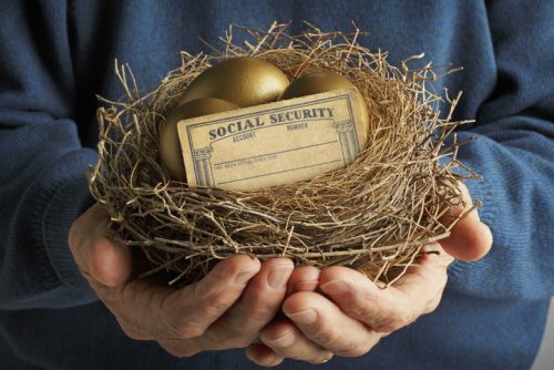 Man Holding Nest With Golden Eggs And Social Security Card