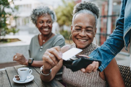 Senior woman making spending money at a restaurant.