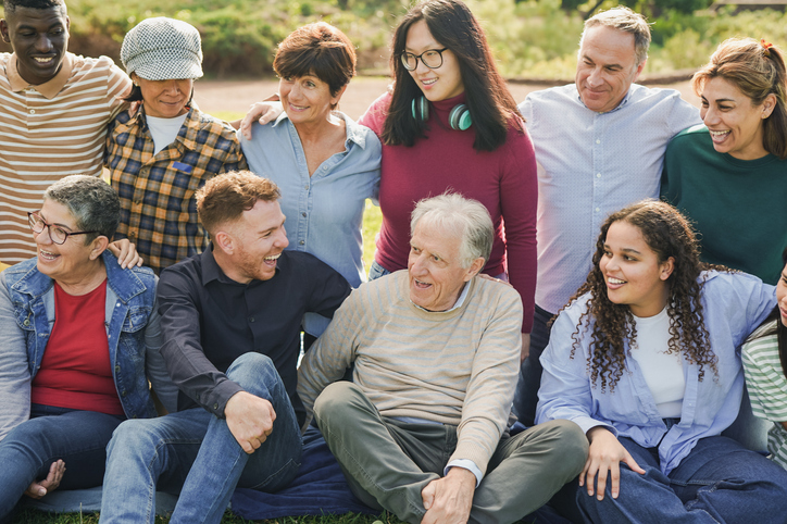 Group of people of different generations sitting together outside.