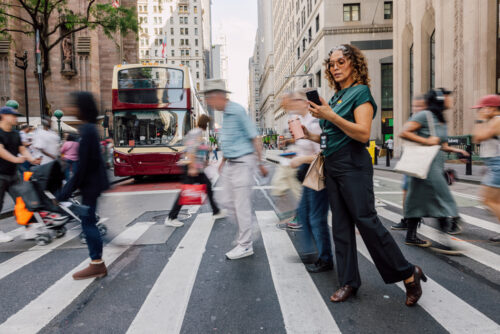 People of all ages walking on a busy street.